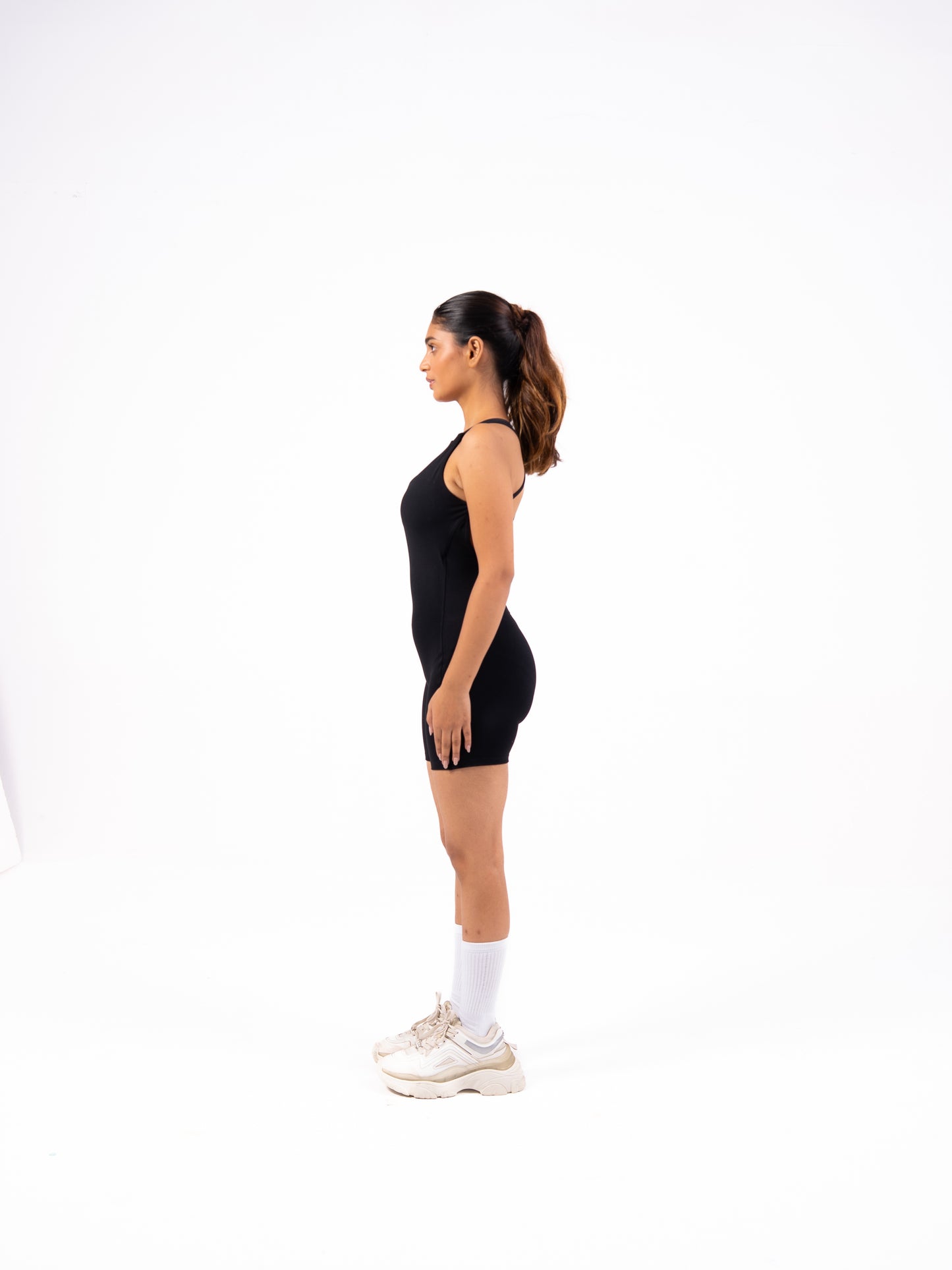 Woman wearing a black sleeveless dress on a white background