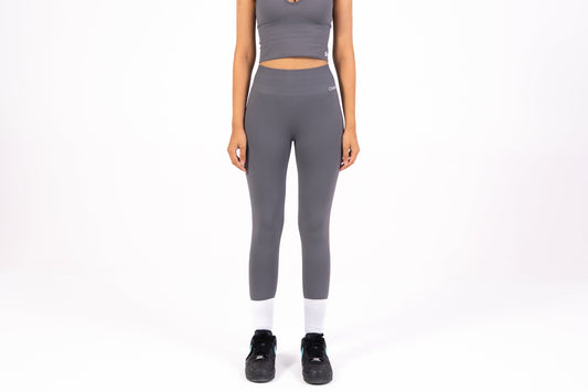 Woman wearing a gray athletic outfit on a white background