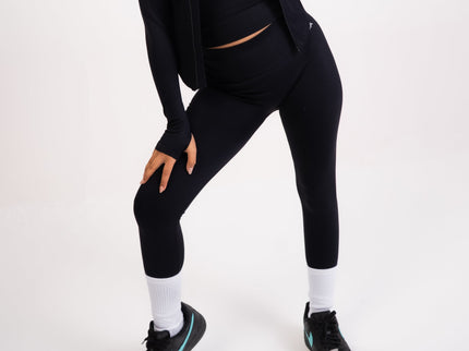 Woman wearing a black athletic outfit on a white background