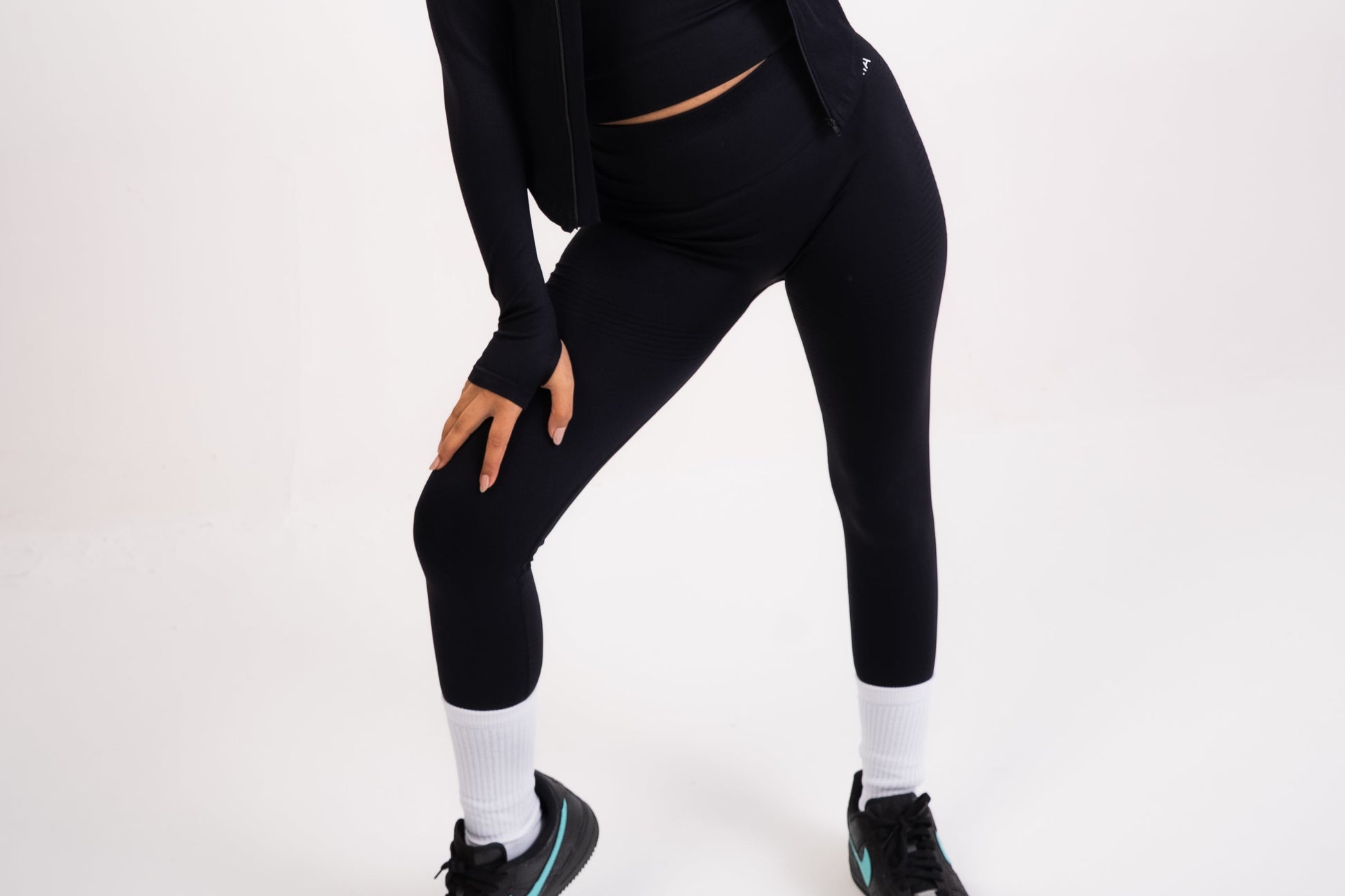 Woman wearing a black athletic outfit on a white background