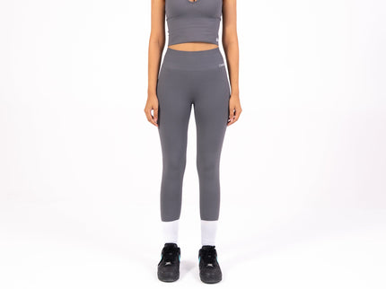 Woman wearing a gray athletic outfit on a white background