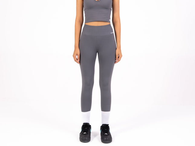 Woman wearing a gray athletic outfit on a white background