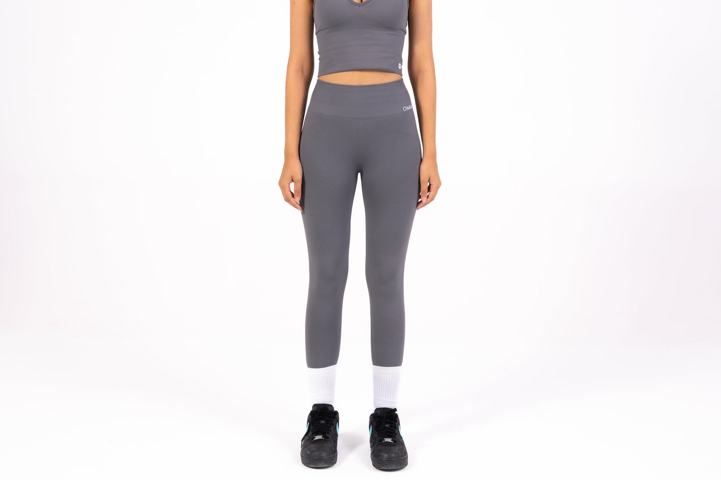 Woman wearing a gray athletic outfit on a white background