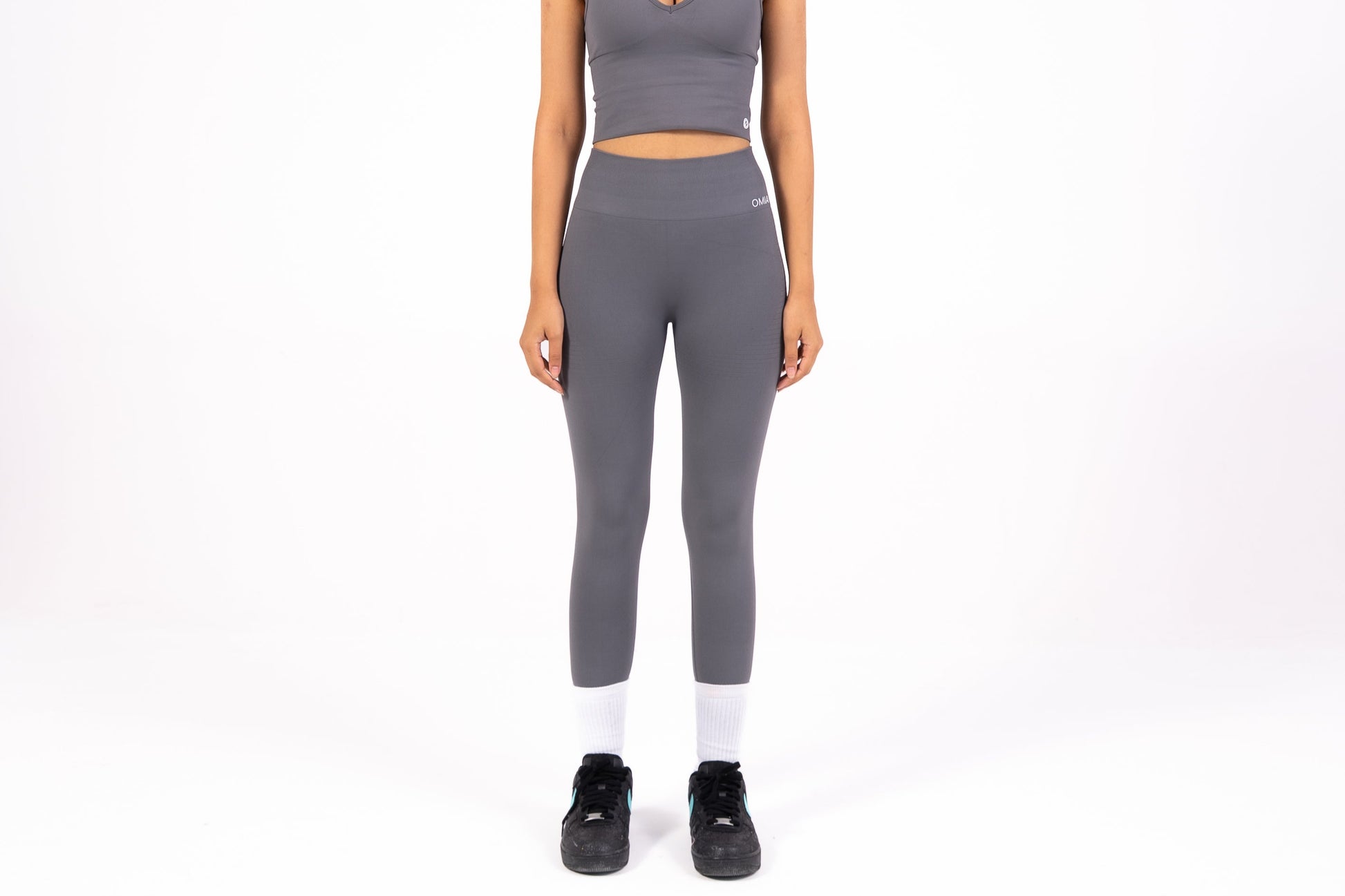 Woman wearing a gray athletic outfit on a white background