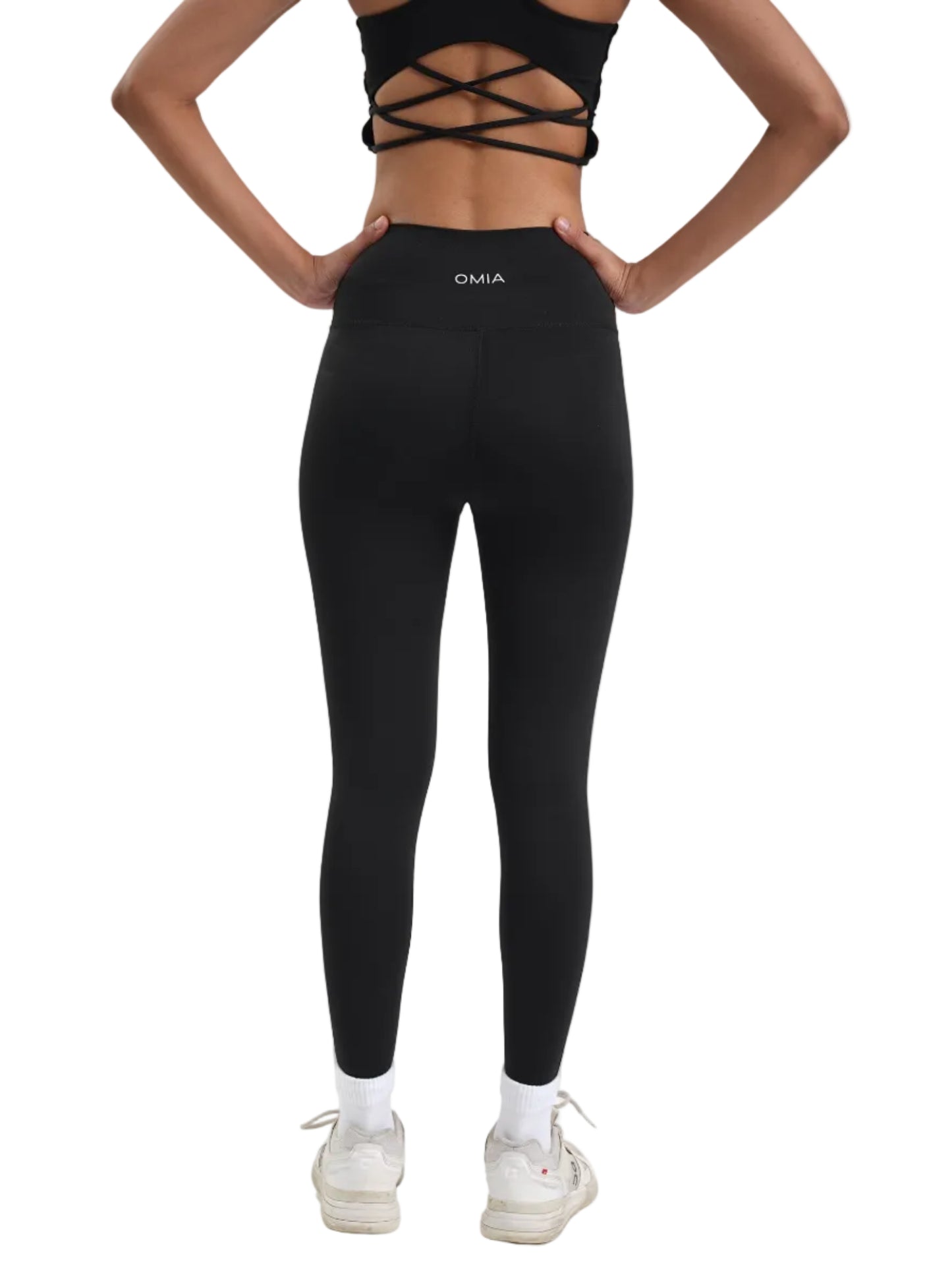 Person wearing black leggings with a brand logo on a white background