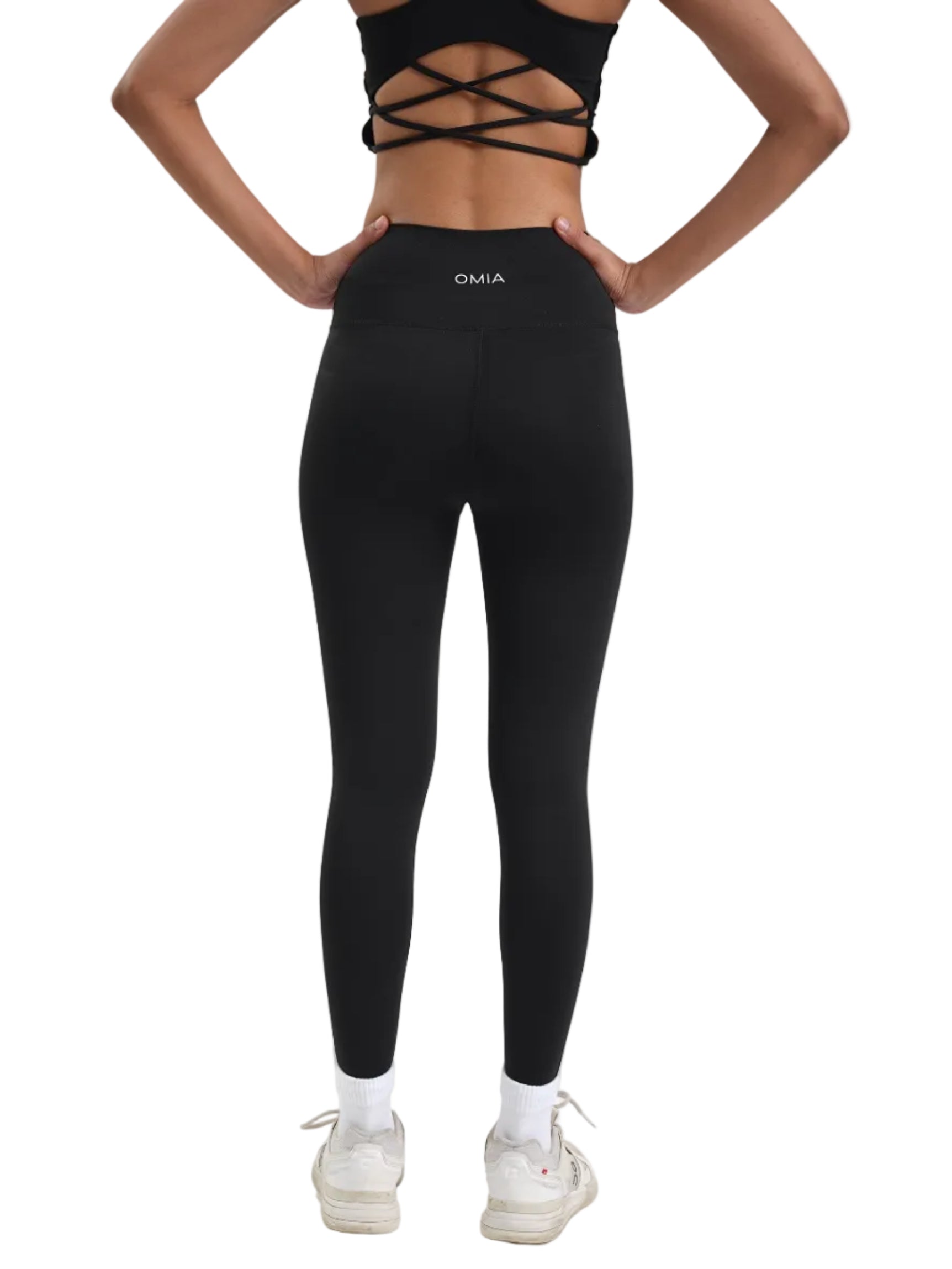 Person wearing black leggings with a brand logo on a white background